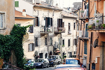 Narrow European Street with Old Buildings and Parked Cars