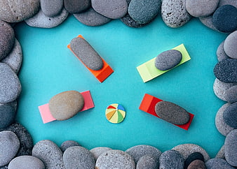 Flat lay of smooth stones on colorful sticky notes with umbrella