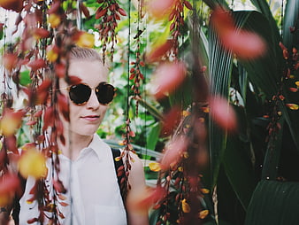 Woman in Sunglasses Amidst Tropical Hanging Flowers