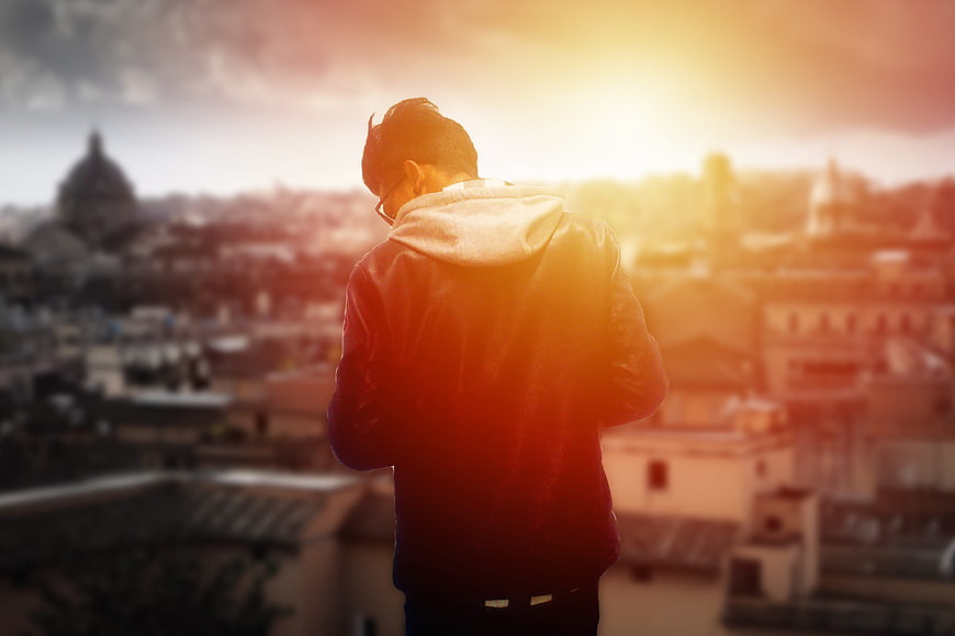 Man Looking at City Skyline at Sunset