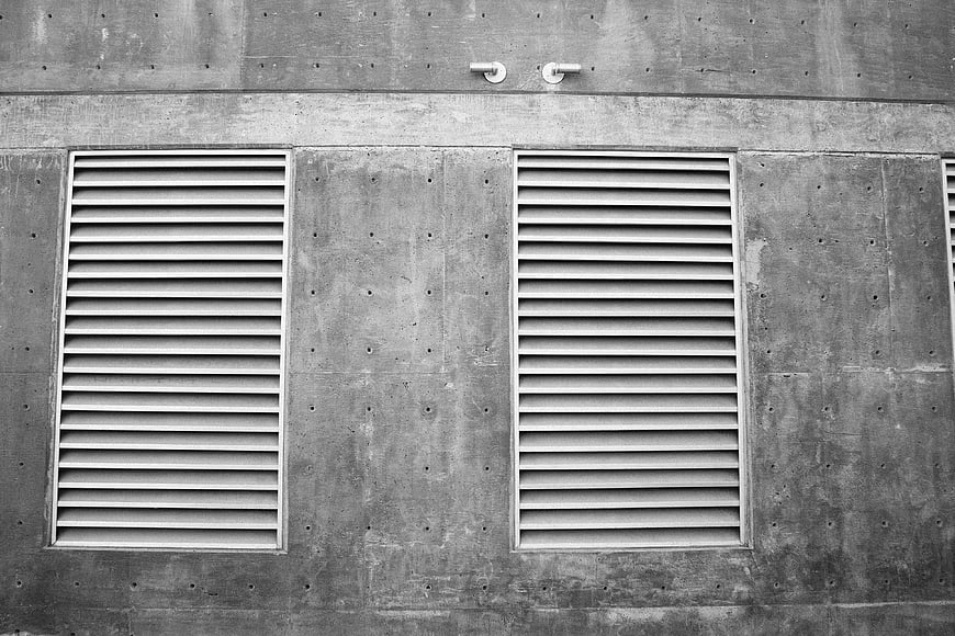Black and white concrete wall with ventilation grilles