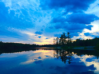 Serene Lake Sunset with Vibrant Blue Sky and Tree Reflections