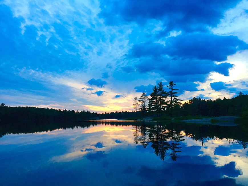 Serene Lake Sunset with Vibrant Blue Sky and Tree Reflections