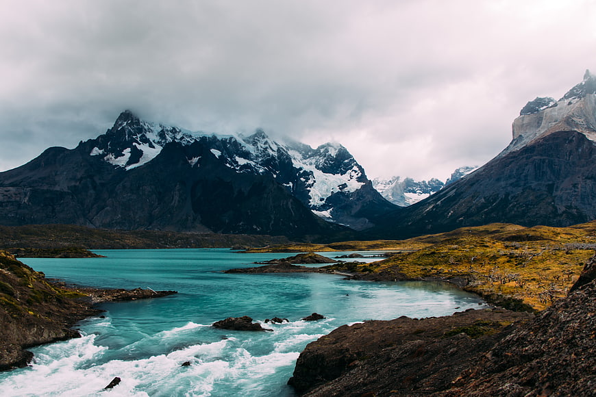 Dramatic turquoise glacial river flowing through Patagonian mountains