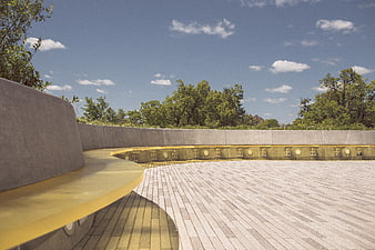 Modern curved concrete bench in park with blue sky