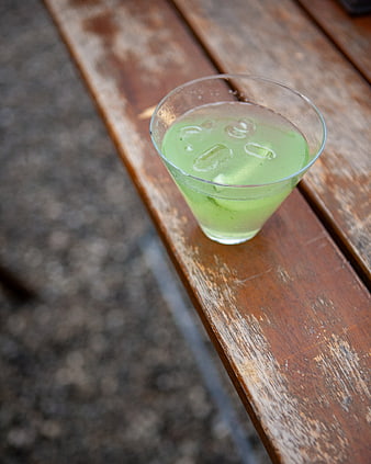 Green cocktail with ice on rustic wooden table