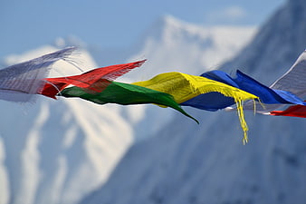 Colorful Tibetan Prayer Flags Waving Against Snowy Himalayan Peaks