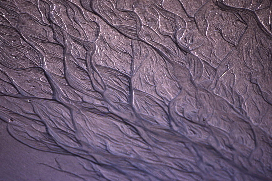 Abstract purple sand texture with wavy branching patterns