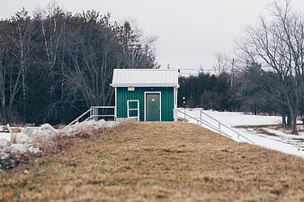 Small Green Cabin in Snowy Winter Landscape