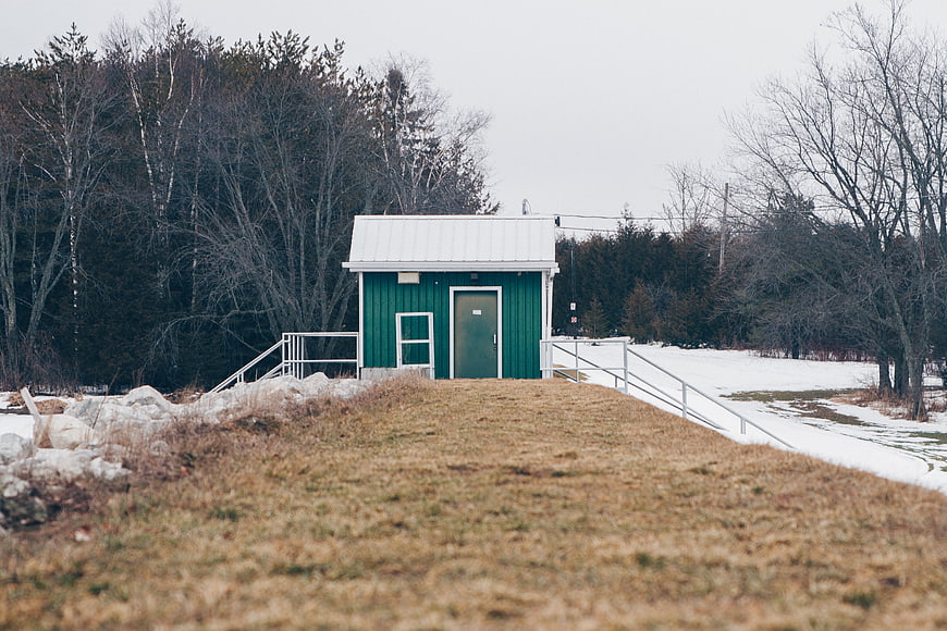 Small Green Cabin in Snowy Winter Landscape