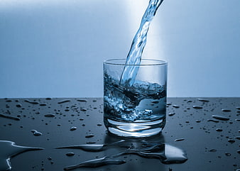 Water Pouring into Glass with Splashes and Droplets