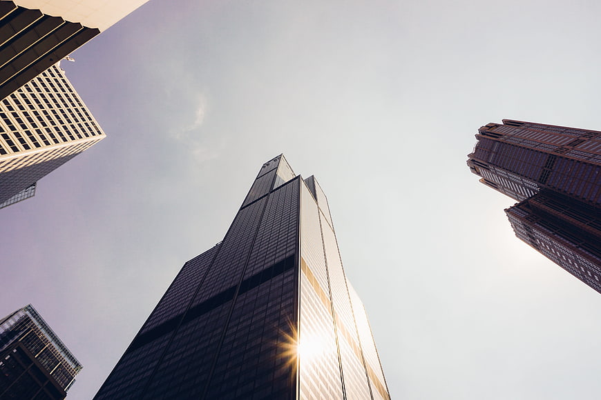 Low angle view of modern glass skyscrapers with sun flare