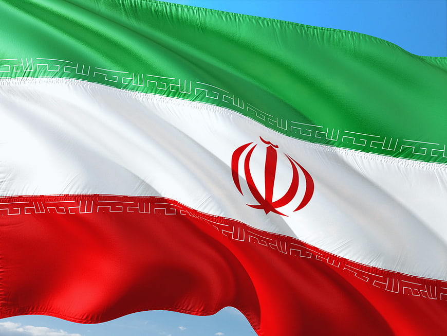 Waving Flag of Iran Against Blue Sky