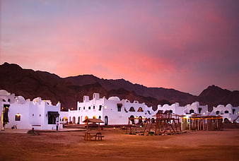 White desert resort buildings at sunset with pink sky