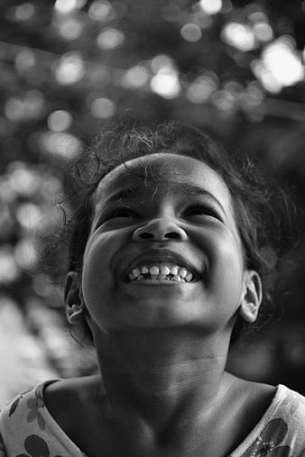 Black and white portrait of a smiling child looking up