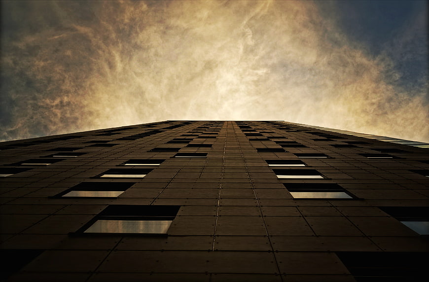 Low angle view of modern skyscraper against dramatic sky