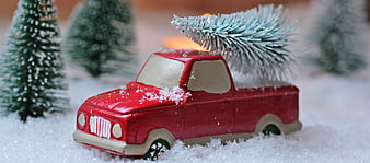 Red Toy Pickup Truck with Christmas Tree in Snow