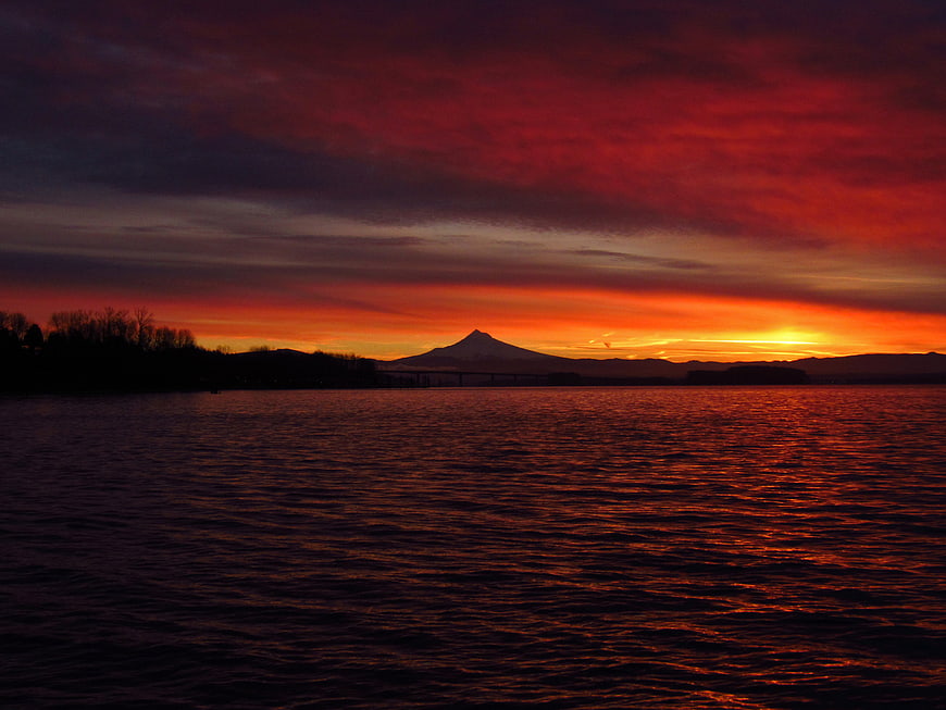 Dramatic Red Sunset Over Lake With Mountain Silhouette