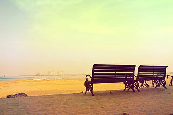 Empty Beach Benches on Sandy Shore with Ocean View