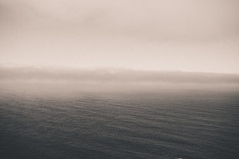 Minimalist foggy ocean horizon with calm water ripples