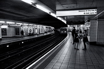Black and white London Underground station with arriving train