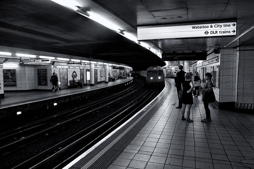 Black and white London Underground station with arriving train