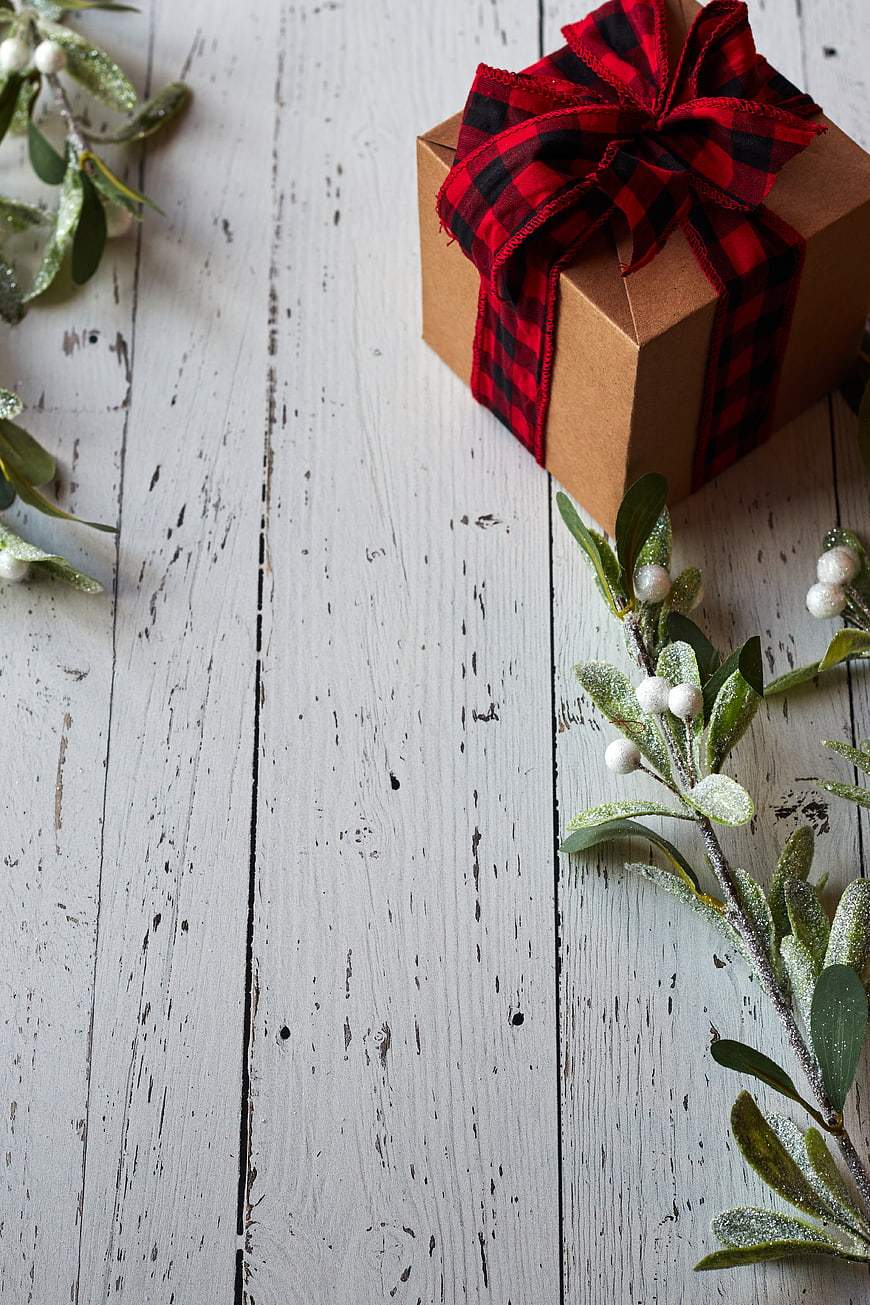Christmas Gift Box with Plaid Ribbon on White Wood