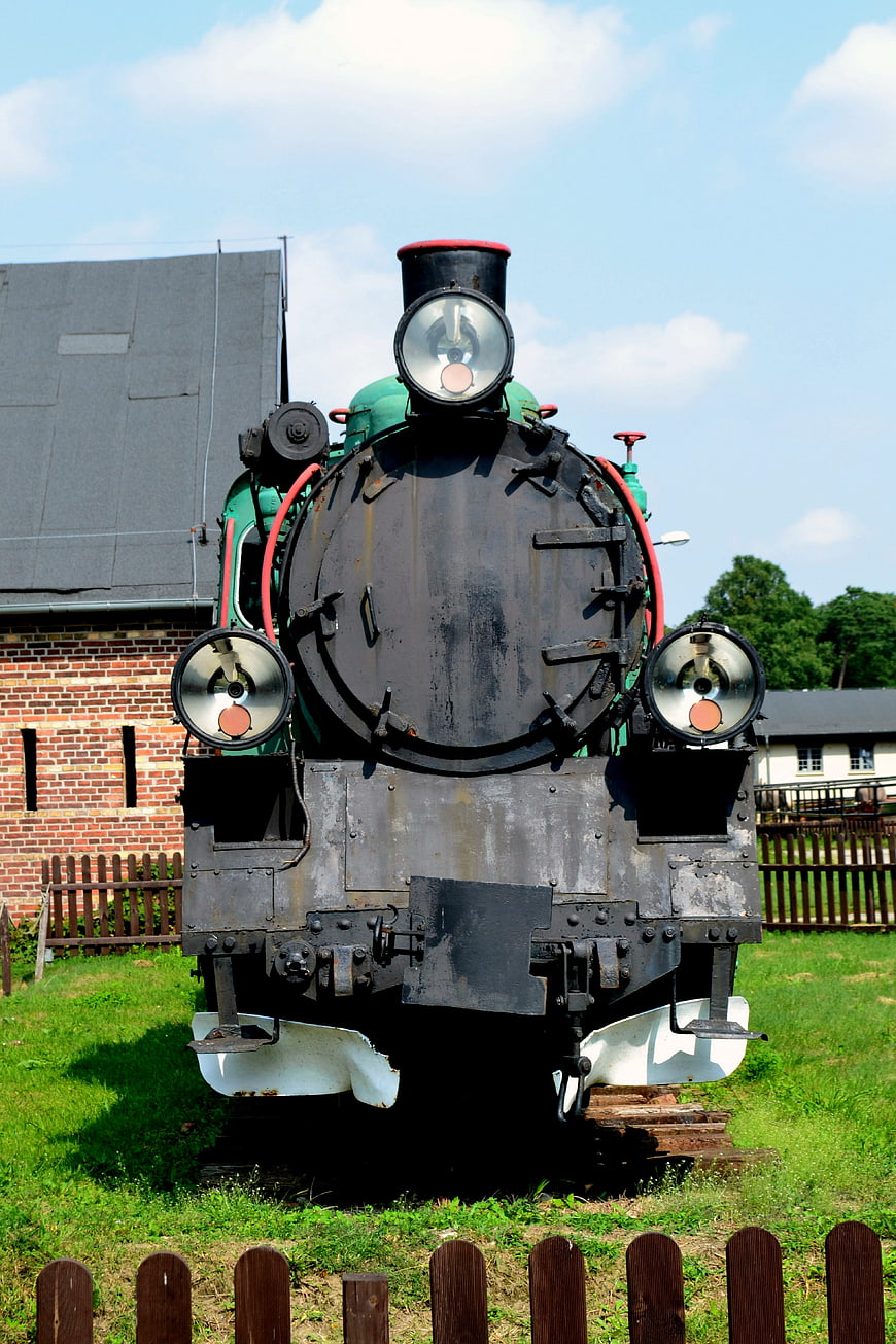 Front view of vintage green steam locomotive on tracks