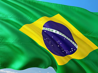Brazilian National Flag Waving Against Blue Sky