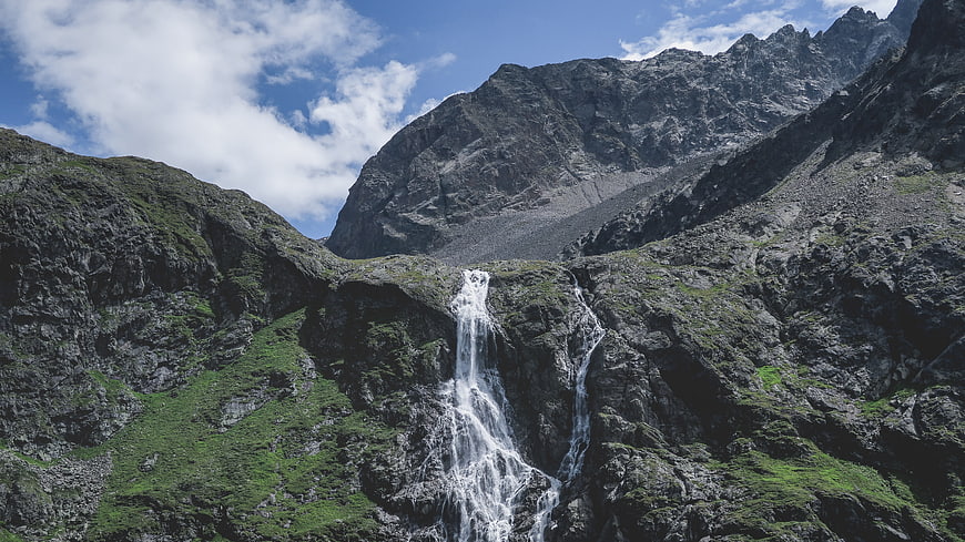 Majestic waterfall cascading down rocky mountain cliffs