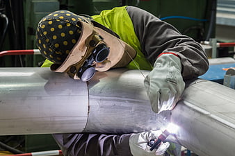 Industrial Welder Working On Stainless Steel Pipe In Factory