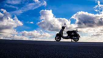 Black Scooter Parked on Road Under Blue Sky