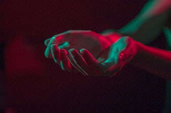 Cinematic hands cupped with red and teal neon lighting