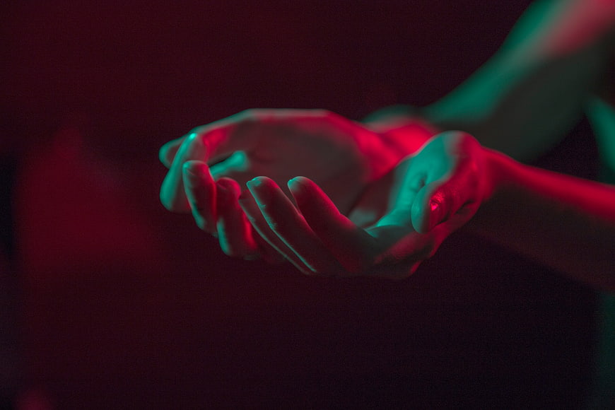 Cinematic hands cupped with red and teal neon lighting