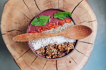 Overhead view of a healthy acai bowl with granola, coconut, and mint