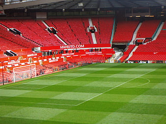 Empty Manchester United Stadium Pitch And Red Seating