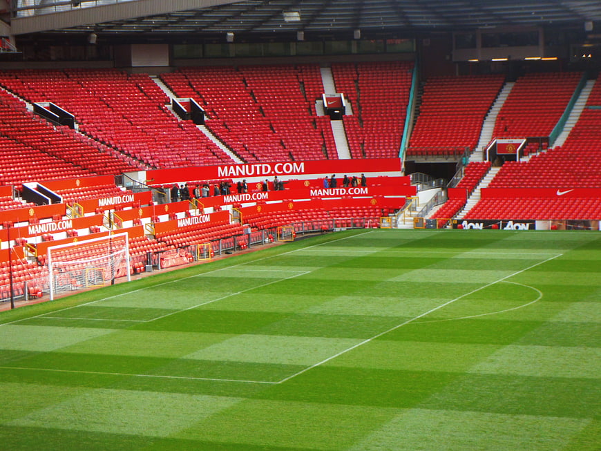 Empty Manchester United Stadium Pitch And Red Seating