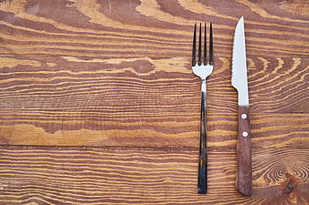 Silver Fork and Wooden Knife on Textured Wood Background