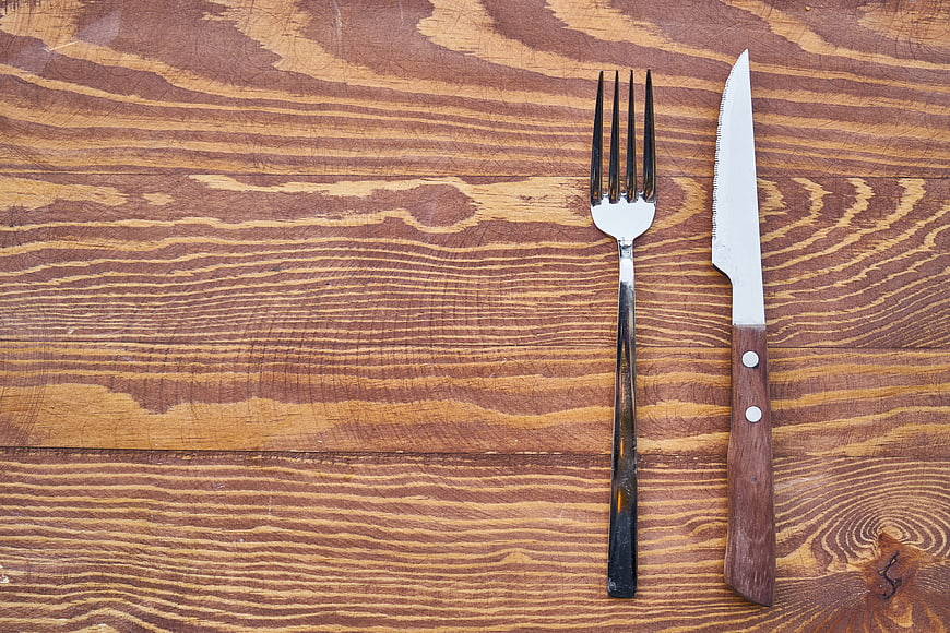 Silver Fork and Wooden Knife on Textured Wood Background
