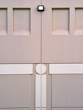 Abstract beige architectural facade with geometric panels and light