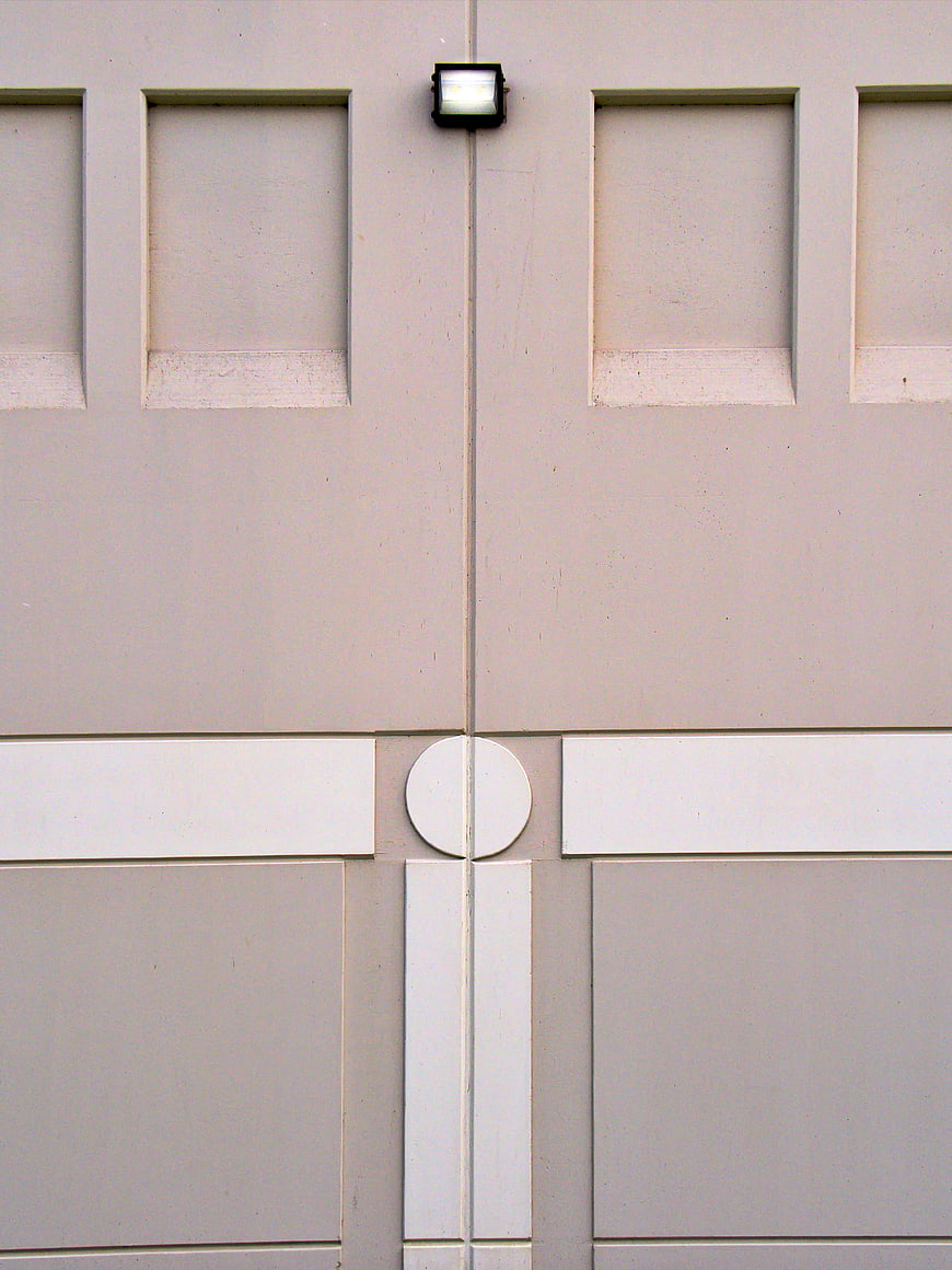 Abstract beige architectural facade with geometric panels and light