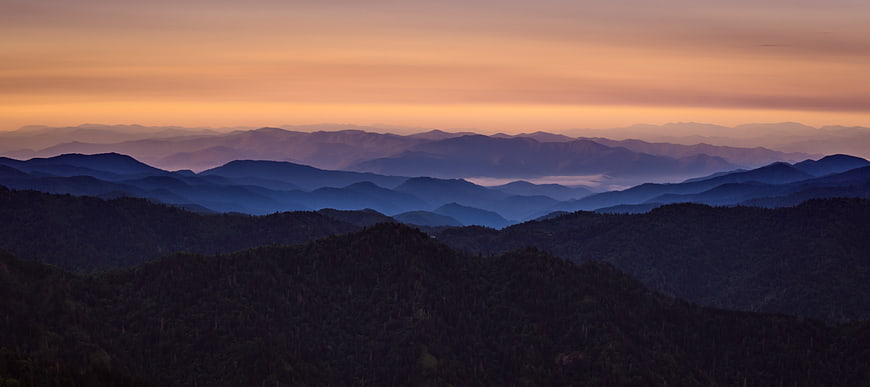 Panoramic Mountain Range at Sunset with Atmospheric Haze