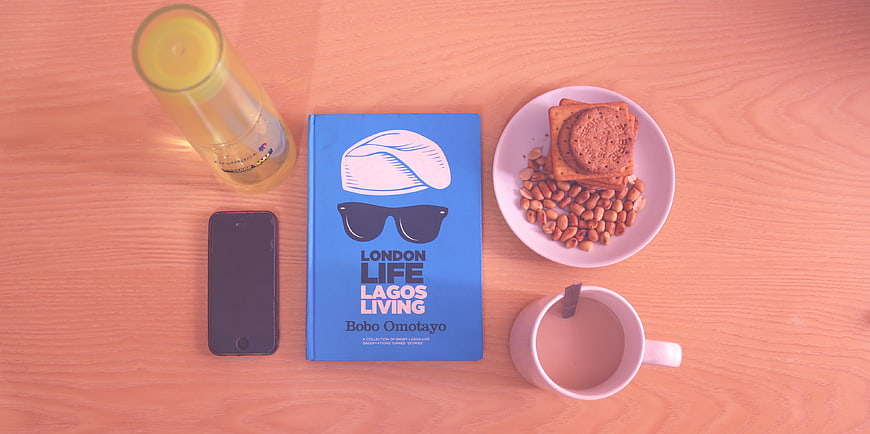 Flat lay of book, coffee, snacks, and smartphone on wooden table