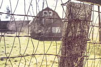 Rustic Wire Fence with Blurred Barn Background