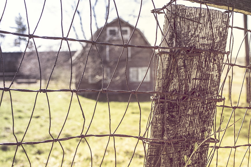 Rustic Wire Fence with Blurred Barn Background