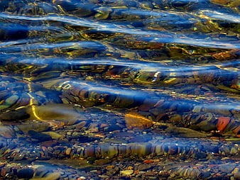 Clear rippling water over smooth river stones