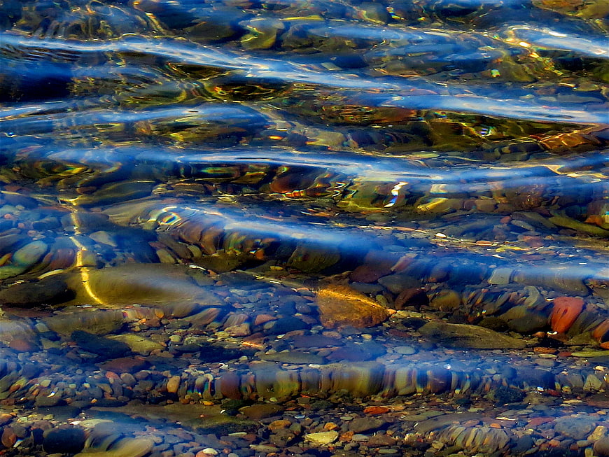Clear rippling water over smooth river stones