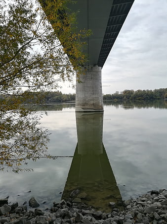 Concrete Bridge Pillar Reflection in Calm River