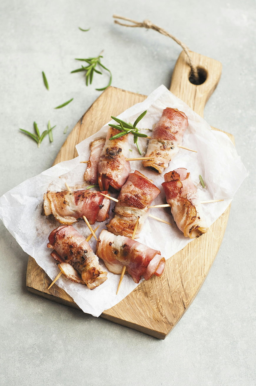 Bacon-Wrapped Appetizers on Wooden Board with Rosemary