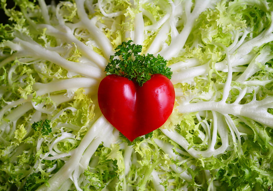 Heart-shaped red pepper on frisée lettuce bed